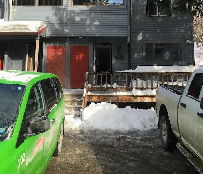 Home with snow and SERVPRO green service van