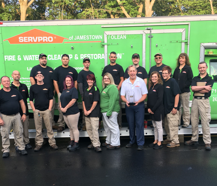 A group of SERVPRO workers standing in front of a truck. 