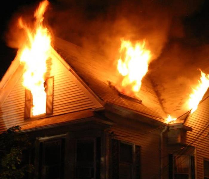 A home with a fire blazing in the night.