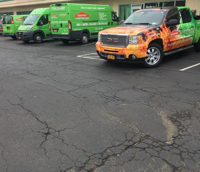 Four SERVPRO vehicles parked in a parking lot. 