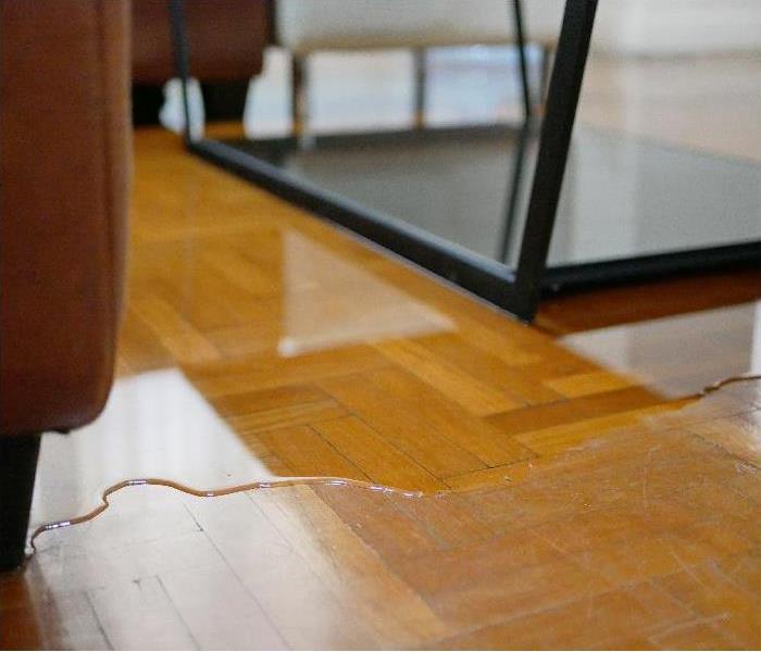 Close up of water flooding on living room parquet floor in a house